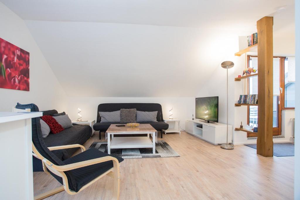 Una sala de estar con un sofá, una mesa y un televisor. en Welcome in - Am Kleehagen 51-F, Niedersfeld-Winterberg, en Winterberg