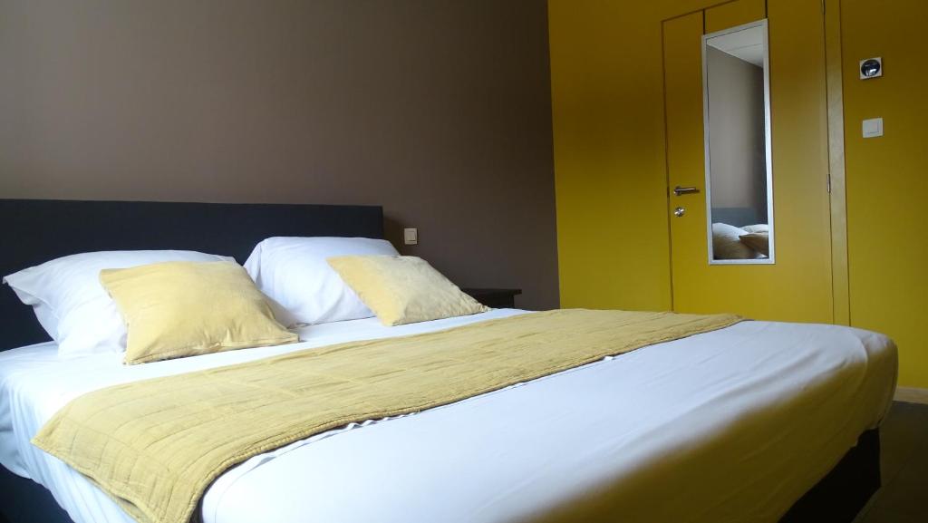 a bedroom with a large bed with white sheets and pillows at Côté Grange in Tournai