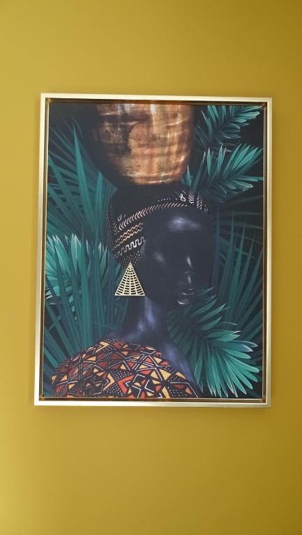 a framed picture of a black woman with a basket at Côté Grange in Tournai