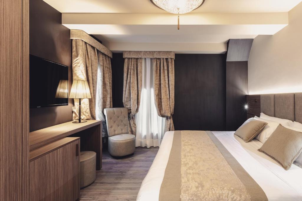 a hotel room with a bed and a chair at Hotel Aquarius Venice - Ascend Collection in Venice