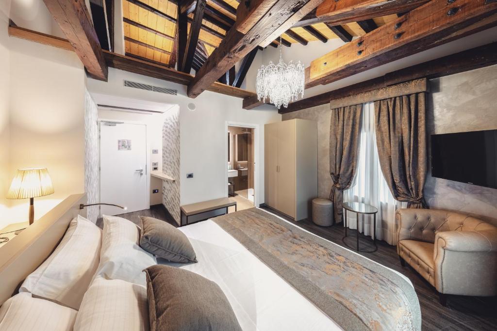 a large bedroom with a large bed and a chandelier at Hotel Aquarius Venice - Ascend Collection in Venice