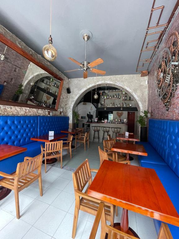 un restaurante con mesas de madera y cabinas azules en Hotel Mangata, en Cartagena de Indias