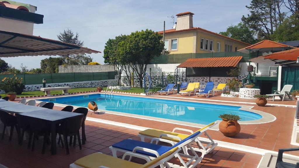 a swimming pool with chairs and a table and a table and chairsitures at VIVENDA TABORDA in Viana do Castelo
