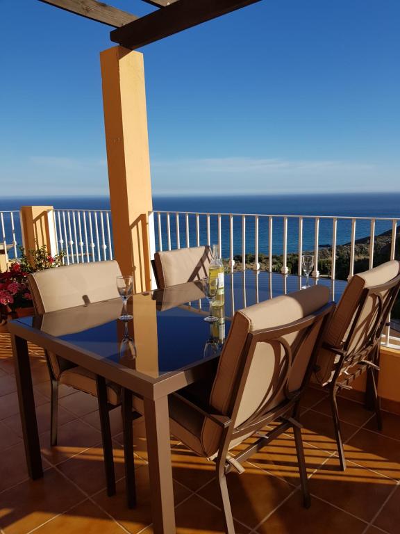 een tafel en stoelen op een balkon met uitzicht op de oceaan bij South Facing Apartment, Fantastic Sea Views,Terrace, 300m beach in Mojácar