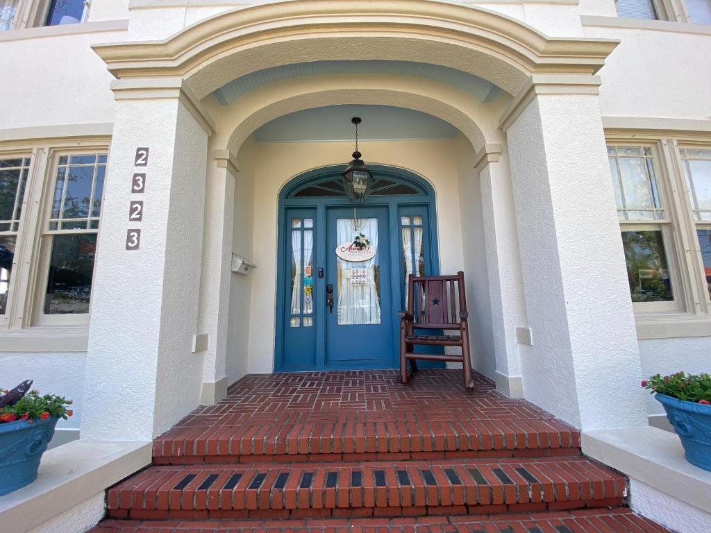 une porte d'entrée bleue d'une maison avec un escalier dans l'établissement Avenue O Bed and Breakfast, à Galveston