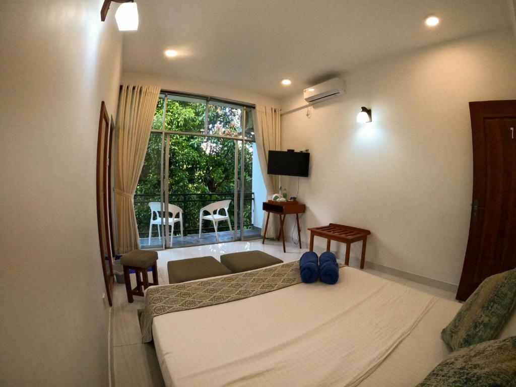 a bedroom with a bed and a couch and a window at Hill Country Villa in Kandy