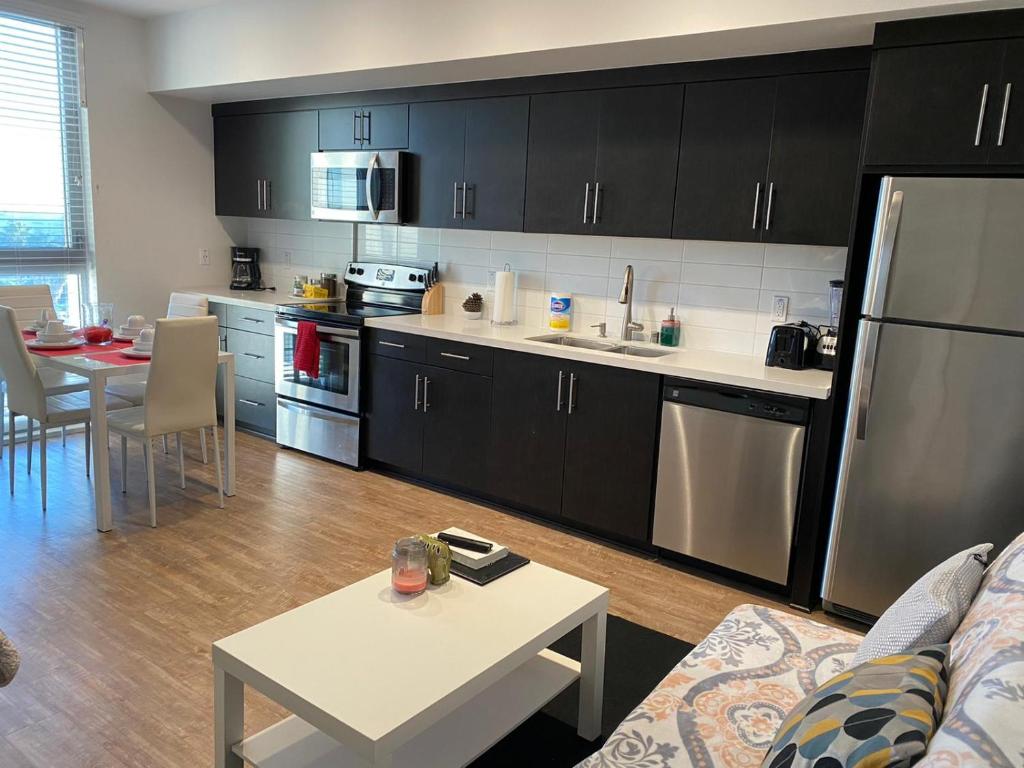 Una cocina con electrodomésticos de acero inoxidable y una mesa en una habitación. en Incredible Hollywood Loft Free Parking, en Los Ángeles