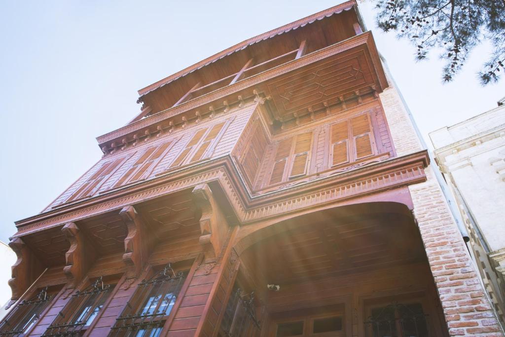 wysoki budynek z drewnianymi oknami wychodzącymi na ulicę w obiekcie Thrace Konak Hotel & SPA w mieście Kırklareli