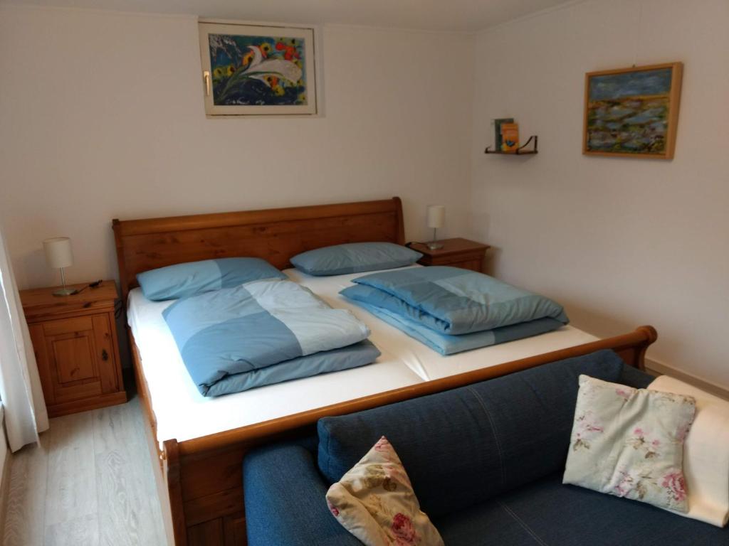 a bedroom with two beds and a couch at Ruhiges, gemütliches Zimmer mit Bad für 2 Personen, mit Gartenterasse in Lübeck