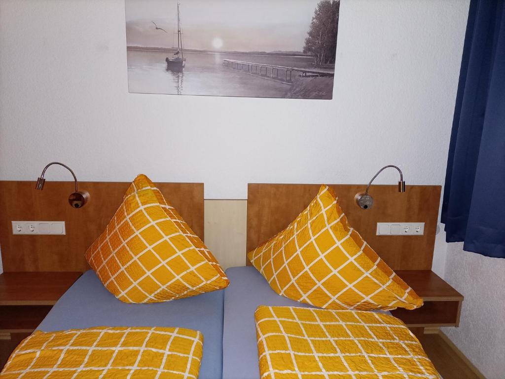 1 dormitorio con 2 camas con almohadas de color naranja y amarillo en Ferienwohnung Georgstrasse, en Bremerhaven