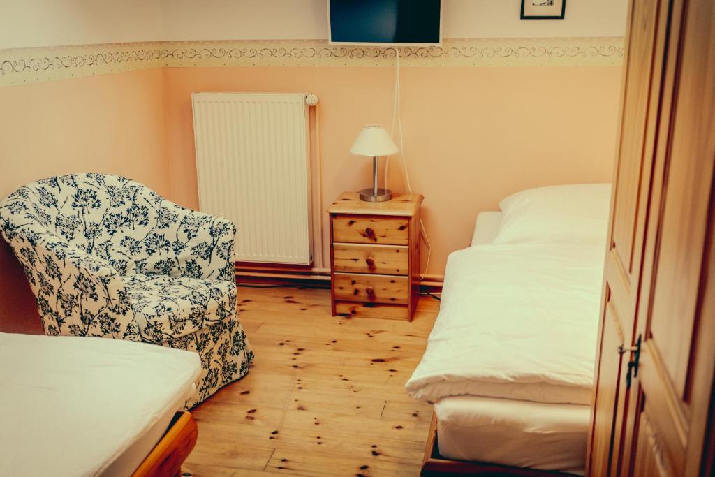 a bedroom with a bed and a chair and a dresser at Inselgaestehaus-Erna in Putbus