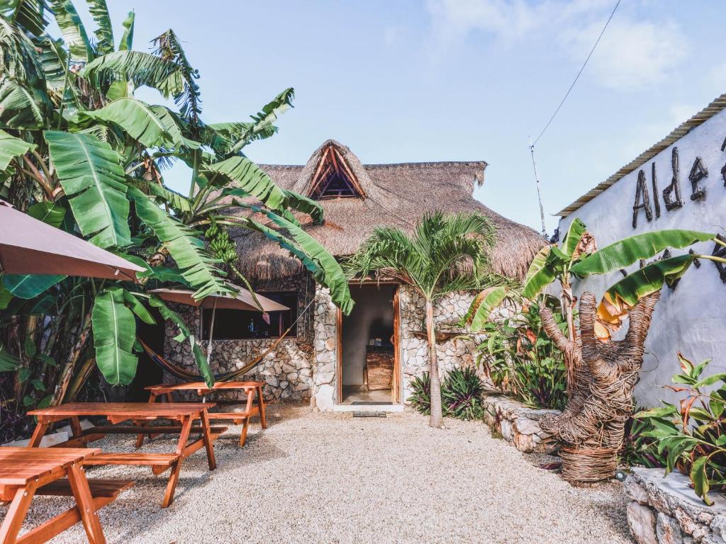 a building with tables and benches in front of it at Aldea Che-Eek , con acceso a un club de playa privado in Bacalar