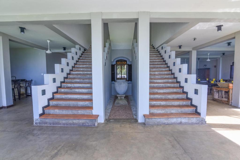 a staircase leading up to a house with white columns at Amanda Beach Villas in Unawatuna