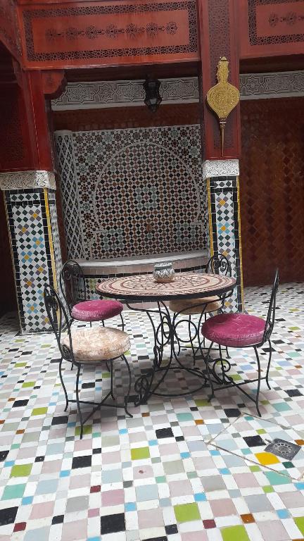 een tafel en twee stoelen en een tafel en een tafel en stoelen bij Riad amal in Fès