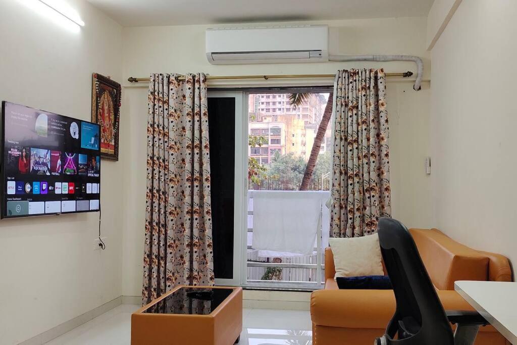a living room with a couch and a window at CITY HOMES PARADISE APARTMENT in Mumbai