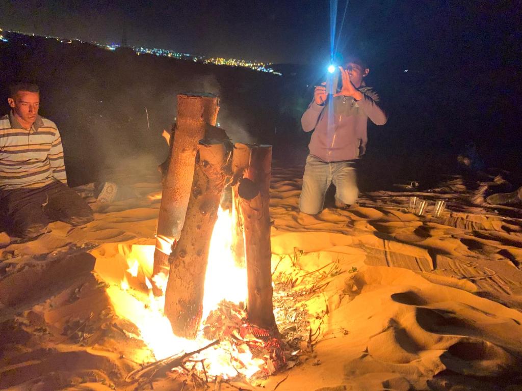 a man taking a picture of a fire at Nubian Farm Aswan in Aswan
