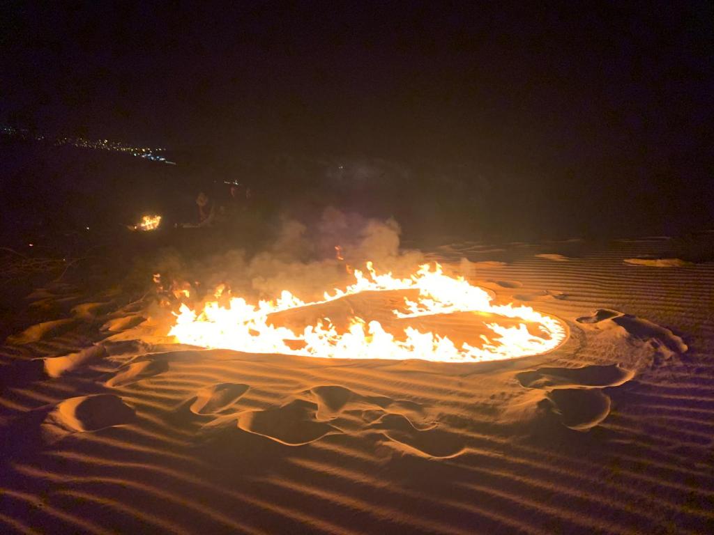 a fire in the middle of a desert at night at Nubian Farm Aswan in Aswan