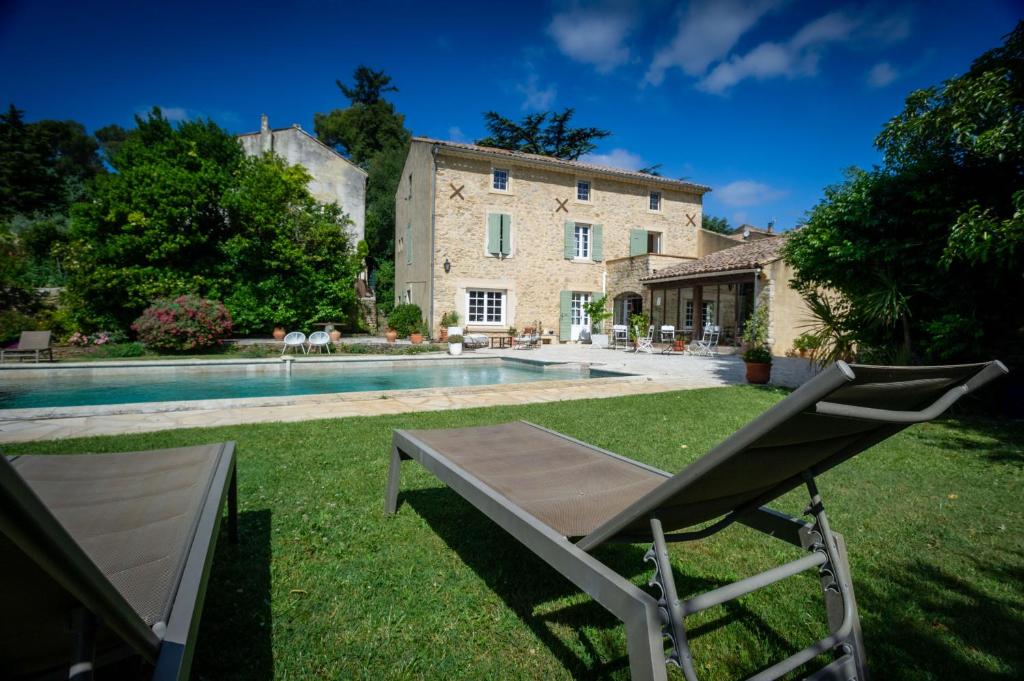 een stoel in de tuin van een huis met een zwembad bij Le mas d'Orsan in Orsan