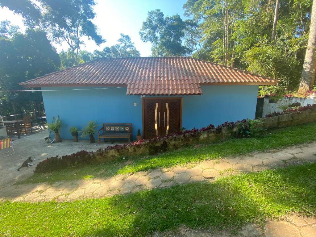 uma casa azul com um telhado vermelho num quintal em Casa de campo com muito verde e paz/2 quartos/Wi-Fi/churrasqueira/ deck/ trilha/ minha cachoeira em Rio Acima