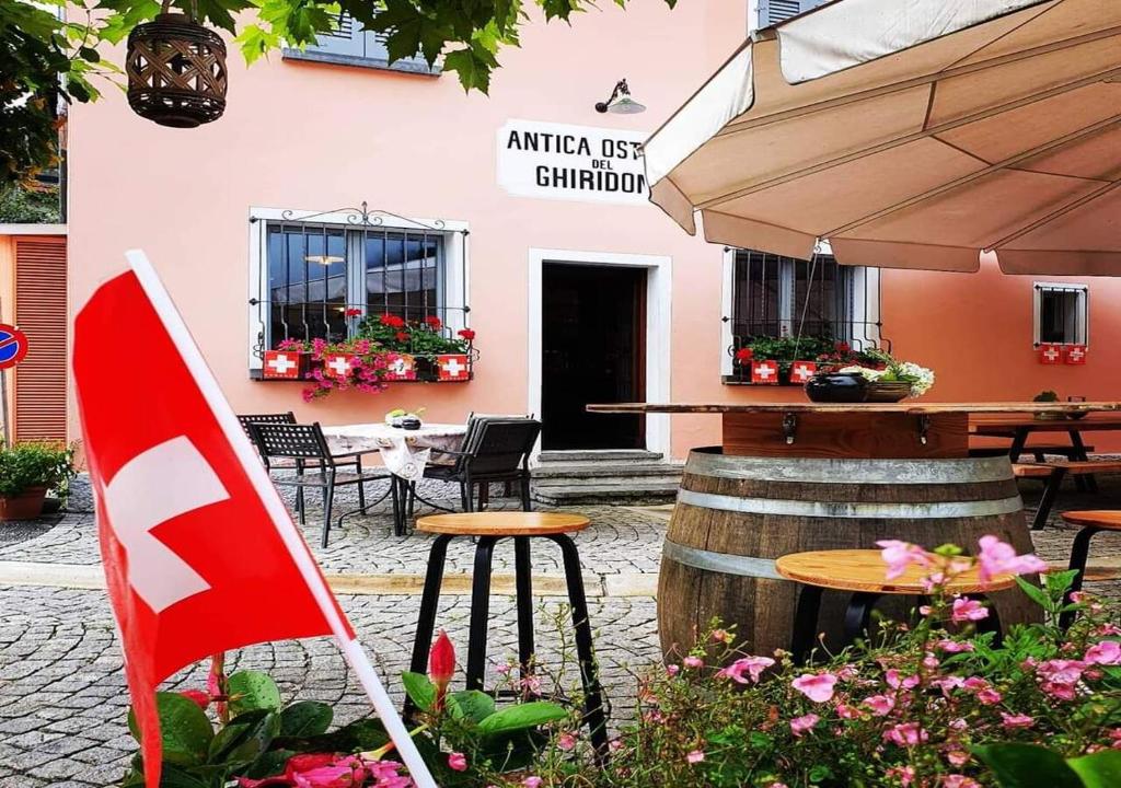 un restaurante con mesa, sillas y bandera en Antica Osteria Ghiridone, en Palagnedra
