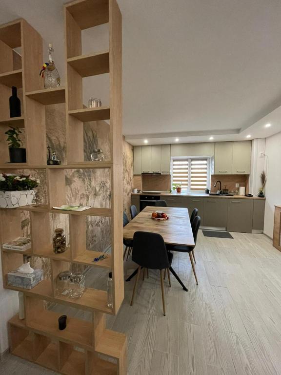 una cucina e una sala da pranzo con tavolo e sedie in legno di Chilia 2 Apartments a Chilia Veche