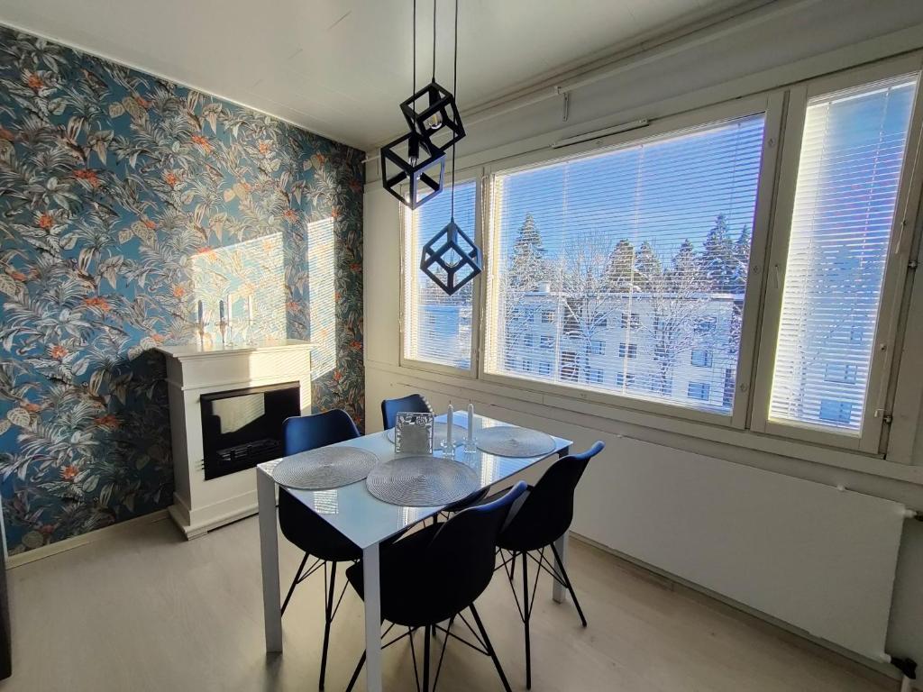 a dining room with a table and chairs and a fireplace at Nika Apartments in Imatra