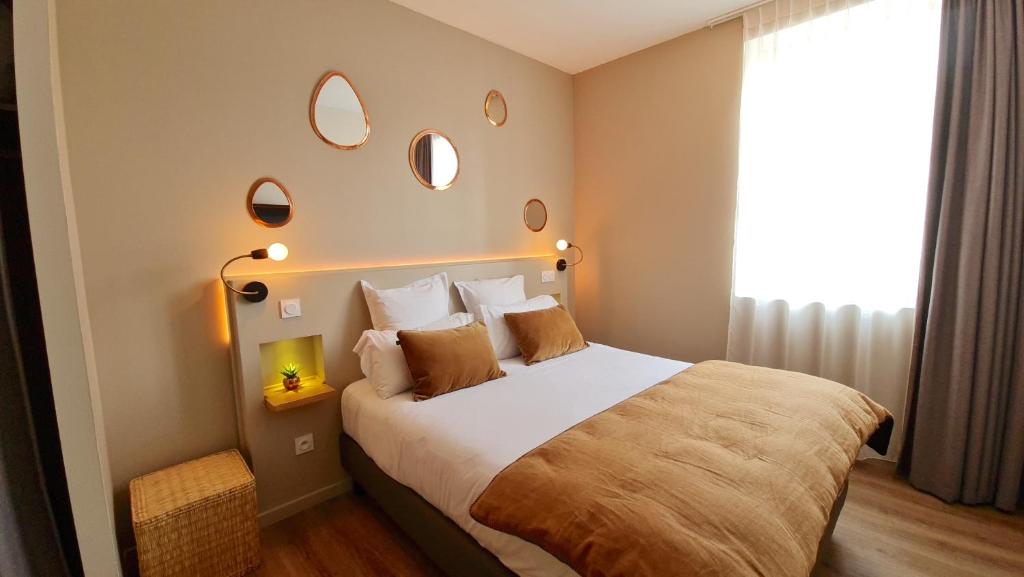 - une chambre avec un grand lit et des miroirs au mur dans l'établissement Hôtel Le C - Boutique Hôtel, à Narbonne