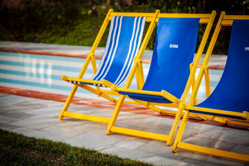 two blue and yellow chairs sitting next to a pool at Da Ilaria primo piano di villa con piscina e parcheggio in Grosseto