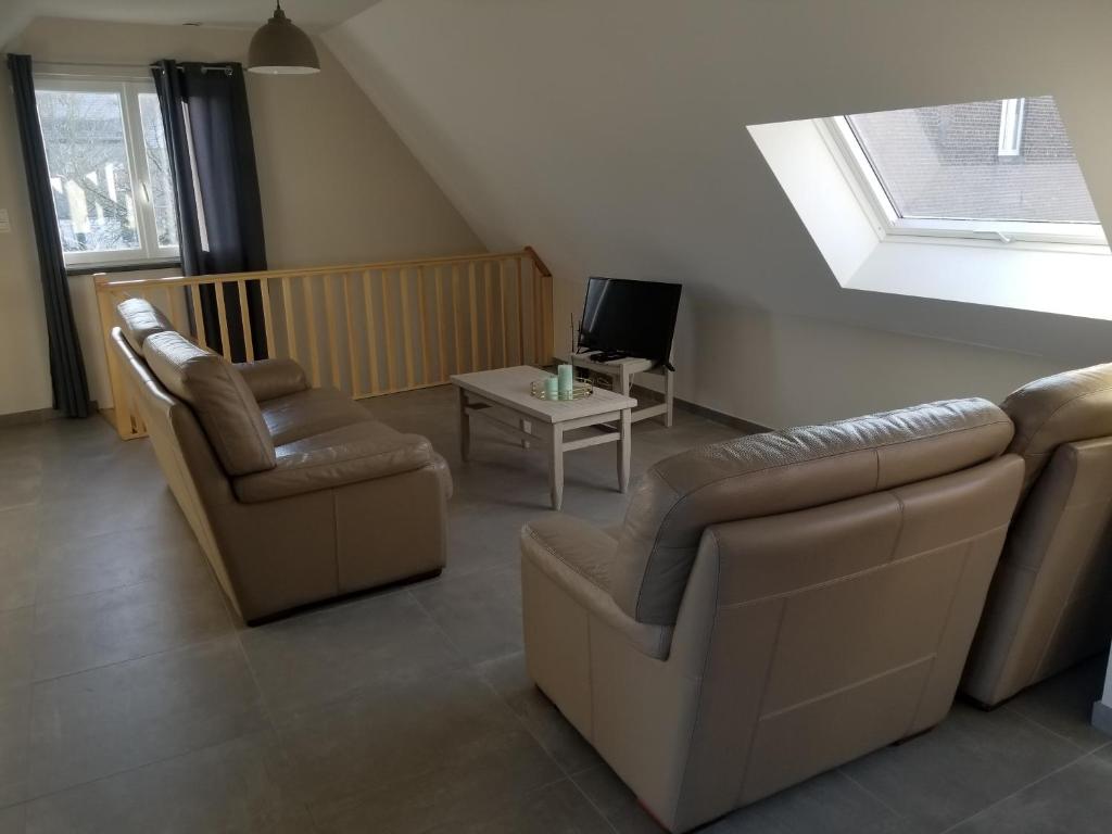 a living room with a couch and two chairs and a tv at Côté Grange in Tournai