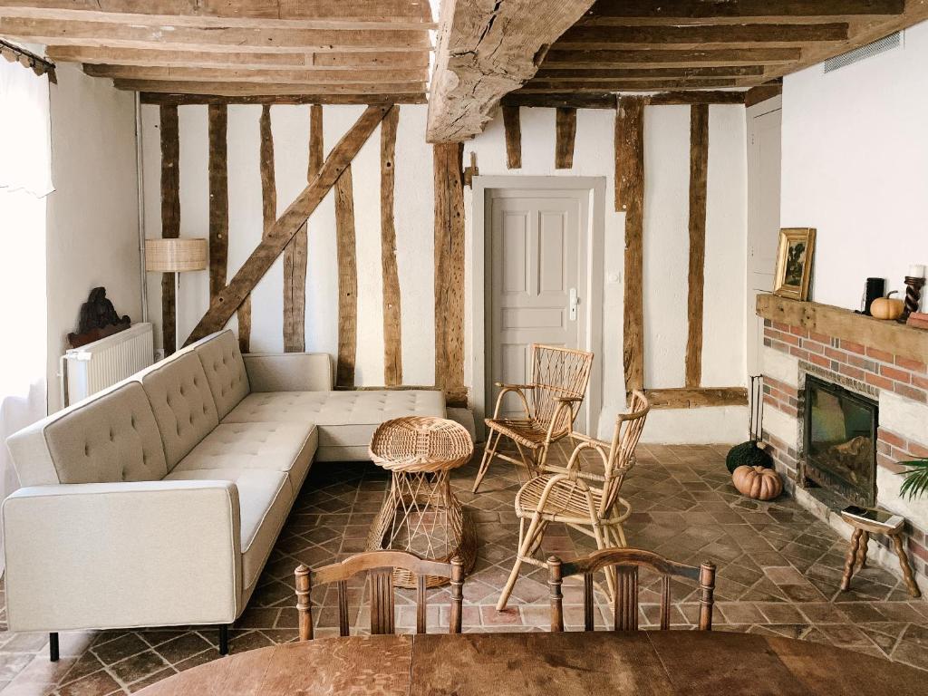 a living room with a couch and chairs and a fireplace at La Maison Pieuse in Villiers-Saint-Benoît