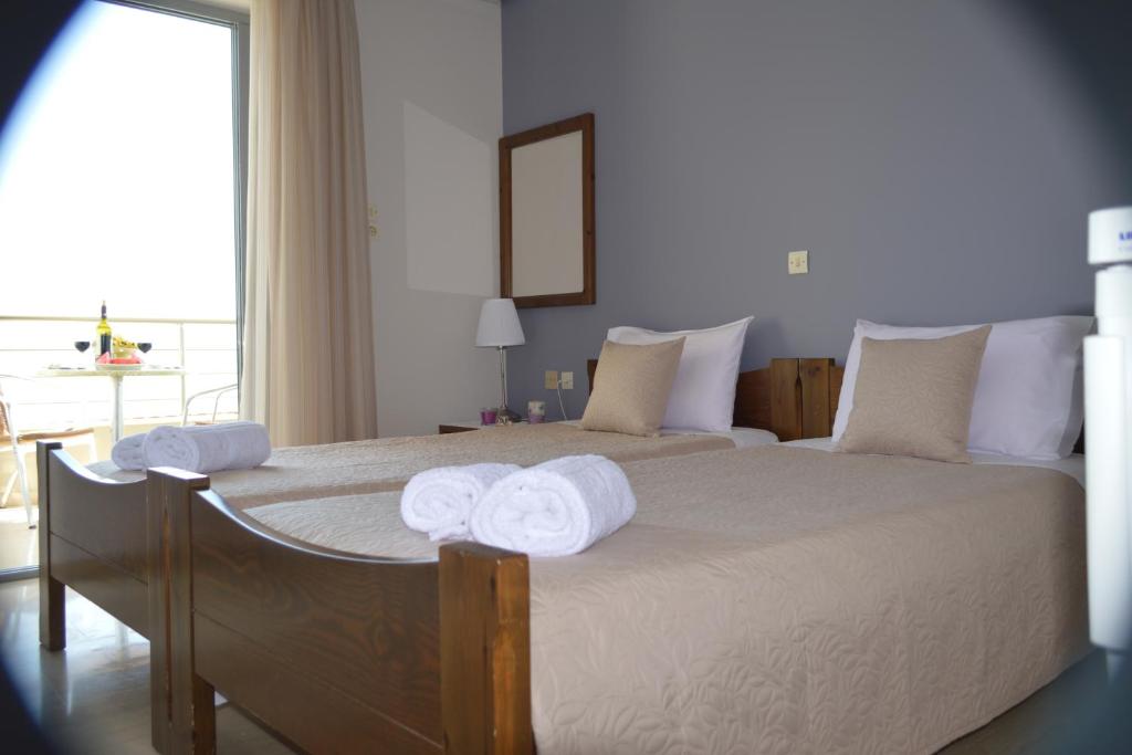 una camera da letto con un grande letto con asciugamani di Almare (Τρίκλινο Δωμάτιο) a Káto Almirí