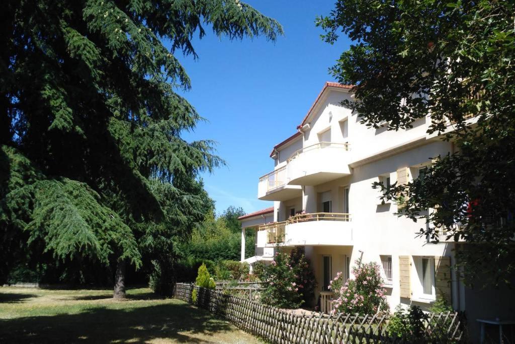 een wit gebouw met een hek en bomen bij Chambre d'hôte Sainte Émilie in Annonay