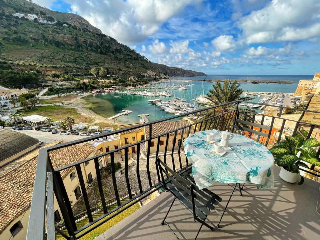een balkon met een tafel en uitzicht op een haven bij Suite Altamarea "Sea View Studios" in Castellammare del Golfo