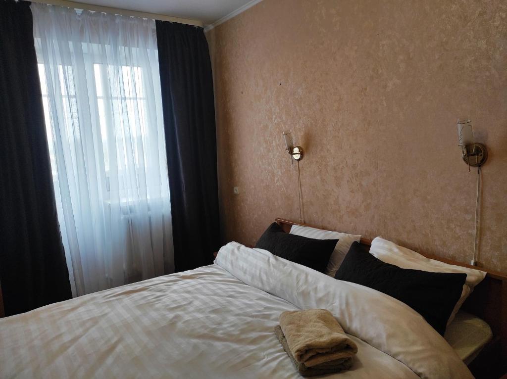 1 dormitorio con 1 cama grande y ventana en Comfortable apartments in centre with 3 bedrooms en Rivne