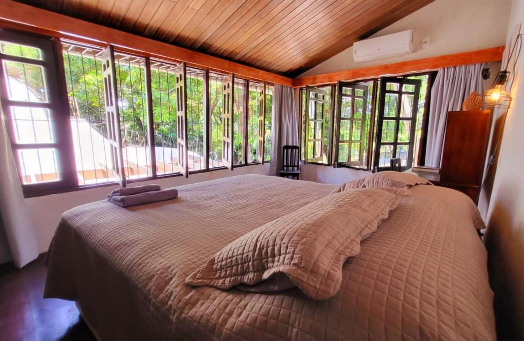 a bedroom with a large bed in a room with windows at Guest House & Art Gallery in Olinda