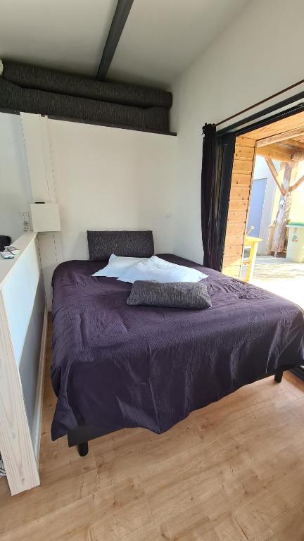 a bedroom with a purple bed and a window at Charmant logement avec parking in Orvault
