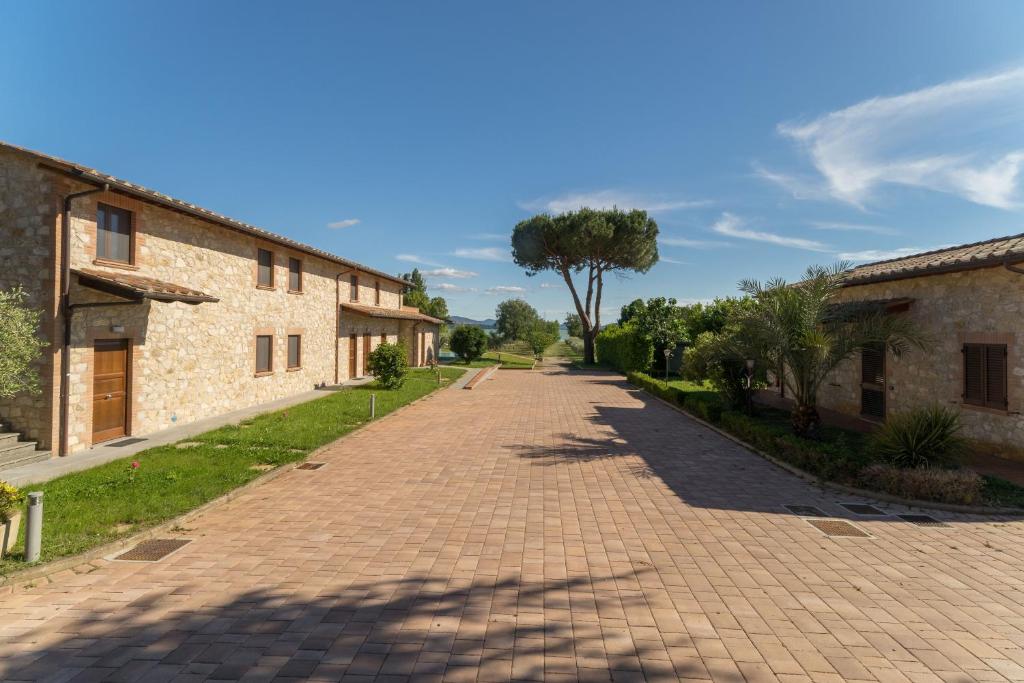 a brick road with a tree in the middle at Lagolivo in Passignano sul Trasimeno