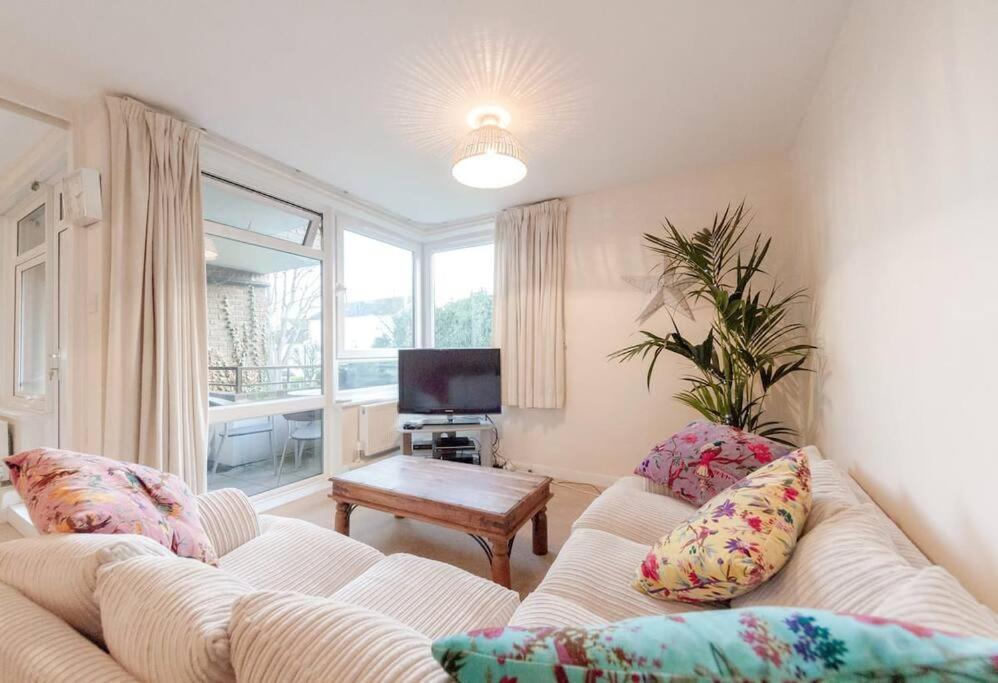 a living room with a white couch and a tv at Spacious Two Double Bedroom Flat in London