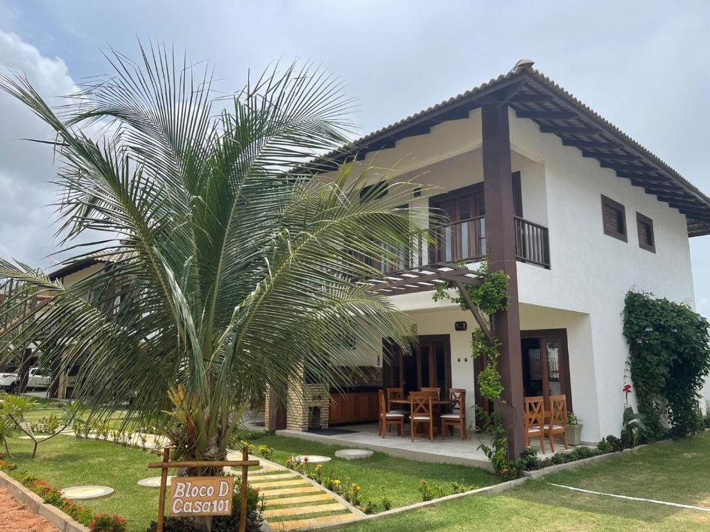 a house with a palm tree in front of it at Paraíso Flecheiras in Trairi