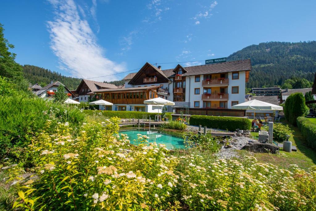 ein Resort mit einem Pool und einem Gebäude in der Unterkunft Hotel Naggler Weissbriach in Weissbriach