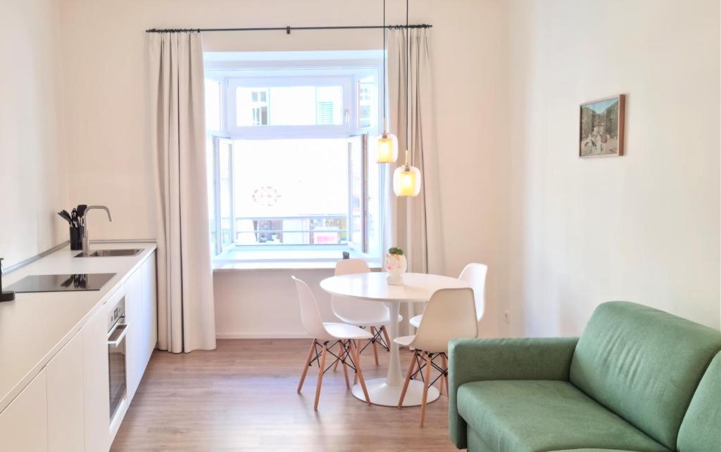 uma sala de estar com uma mesa e um sofá verde em Rosa Apartment with parking historic city center em Merano