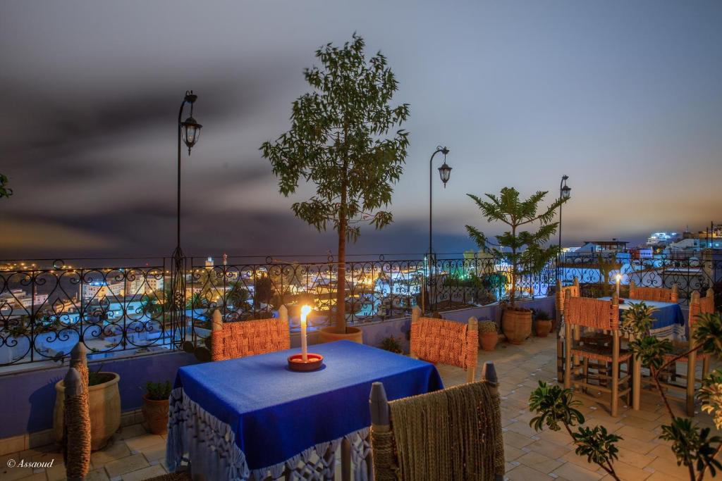 a table with a candle on a balcony at night at Hotel Dar Mounir in Chefchaouen