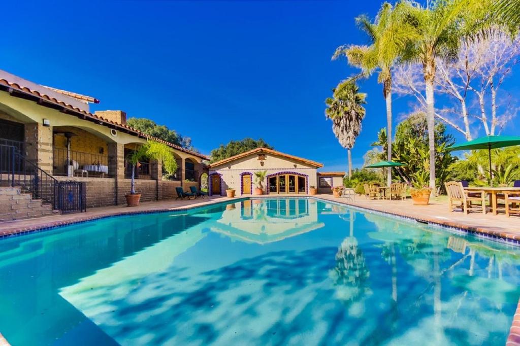 a swimming pool in front of a house at Vineyard Hacienda in El Cajon