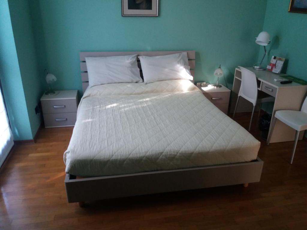 uma cama num quarto com uma secretária e uma cama sidx sidx em I Pini B&B em Castagnito