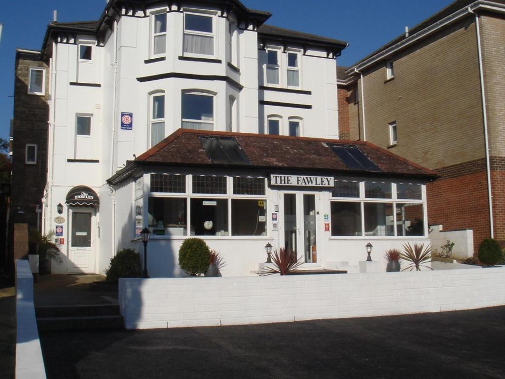 Ein weißes Gebäude mit einem Laden davor. in der Unterkunft The Fawley Guest house in Shanklin