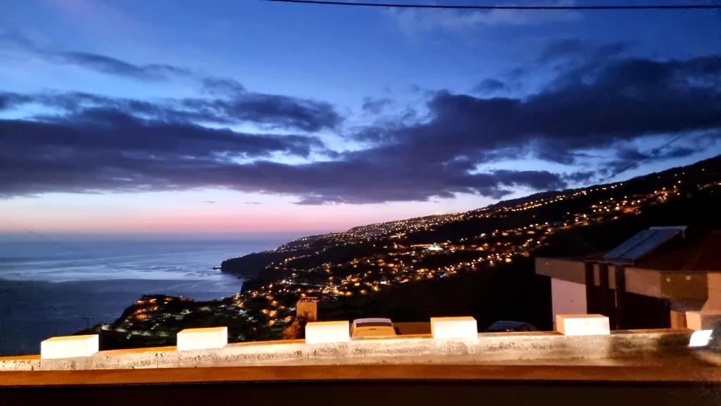widok na światła miasta na wzgórzu w nocy w obiekcie Villa Cassolino w mieście Ribeira Brava