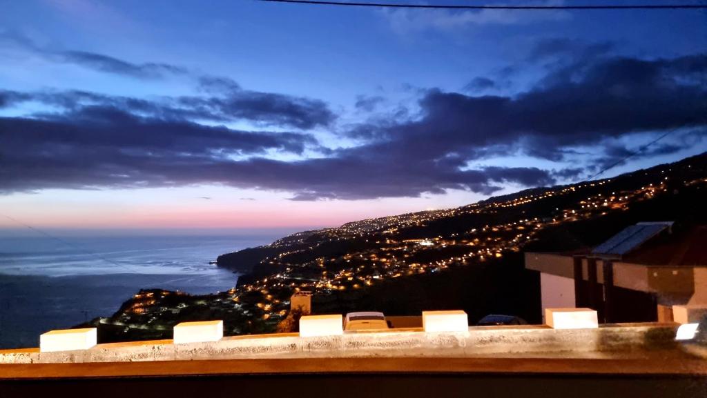 uitzicht op de stadslichten op een heuvel 's nachts bij Villa Cassolino in Ribeira Brava