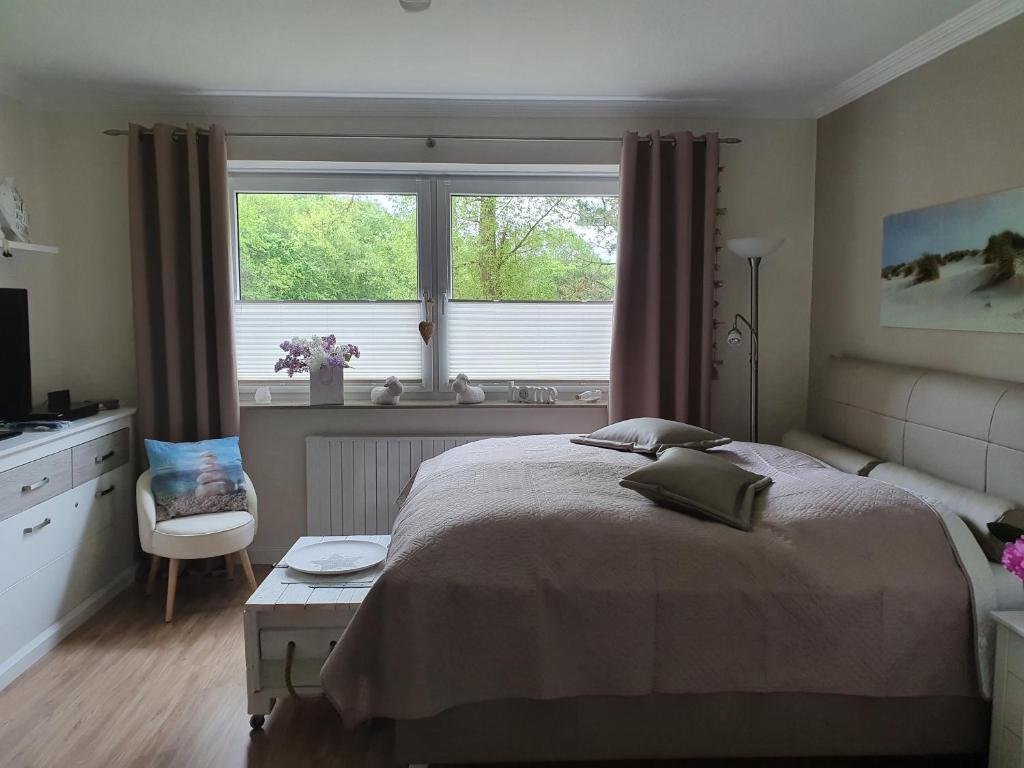 sypialnia z łóżkiem, oknem i krzesłem w obiekcie Appartement Relax Sankt Peter Ording w mieście Sankt Peter-Ording