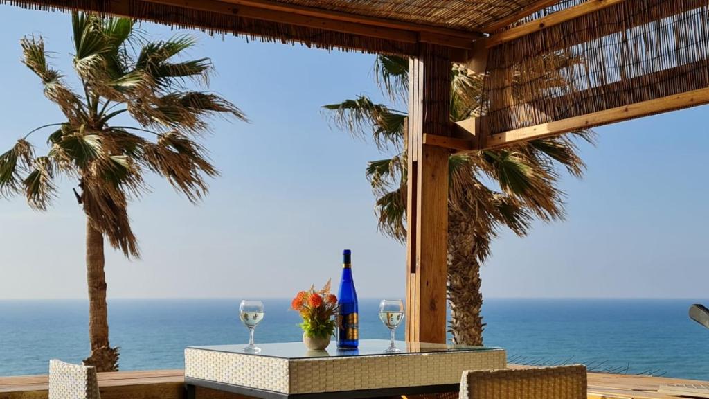 een tafel met twee wijnglazen en een palmboom bij טרסת העץ המלכותית חוף צאנז עם בריכת זרמים פרטית לציבור החרדי in Netanya