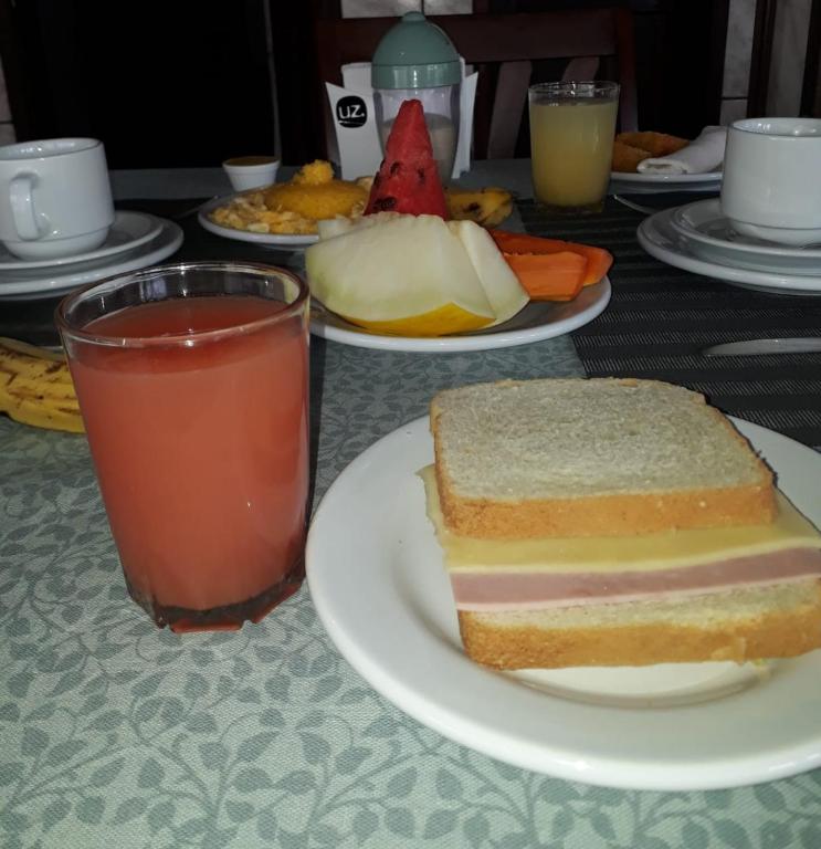 a table with a plate of food and a sandwich and a drink at Pousada Brilho dos Lençóis in Barreirinhas